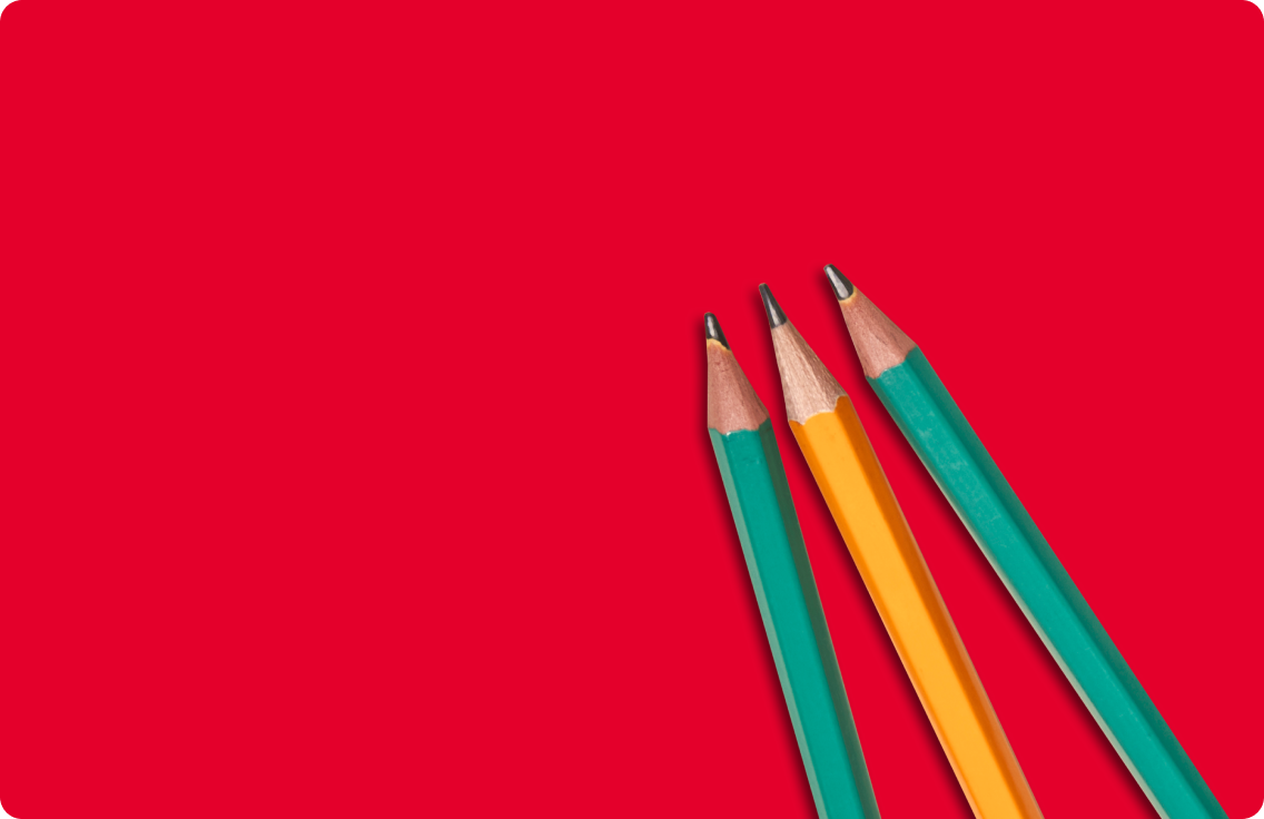 Three pencils on a red surface.